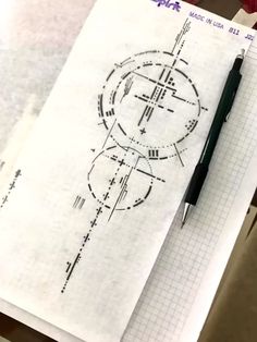 a pen sitting on top of a piece of paper next to a drawing with circles