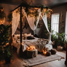 a bedroom with candles lit on the bed and greenery hanging from the ceiling above it