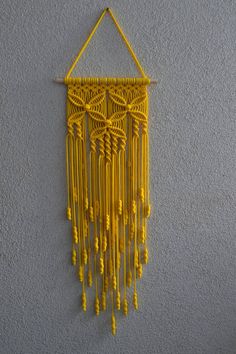 a yellow wall hanging on the side of a gray wall next to a white wall