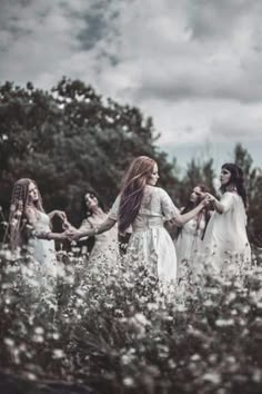 a group of women holding hands in a field