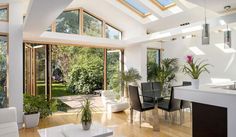 a living room filled with lots of furniture next to a kitchen and dining room table