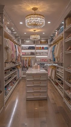 a walk in closet with chandelier and shelves full of clothes on hangers