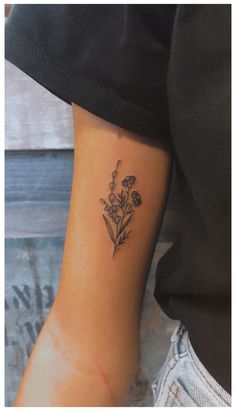 a small flower tattoo on the left inner arm and wrist, with an arrow in the center