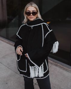 This new coat trend is having a major moment. Get obsessed with the Byron Tassel Scarf Jacket that features a built-in scarf with fringe tassel hem. It has contrast, white embroidered trim, pockets, and feels as cozy as it looks. Get this 'gram-worthy coat before it's gone. Relaxed, oversized fit Built-in scarf Side pockets Contrast white trim 100% Polyester Western Wear Dresses, Scarf Jacket, Scarf With Fringe, Coat Trends, Tassel Scarf, Embroidered Trim, Dresses By Length, Wrap Sweater, Black Friday Shopping