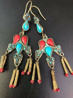 Mega beautiful, oriental earrings from Pakistan complemented with red and turquoise stones. At the ends, delicate springs with beautiful crystals. Measurements. Length 10 cm, width 3 cm. Ceremonial Drop Earrings, Unique Ceremonial Brass Earrings, Unique Latkans Earrings, Festival Plug Dangle Earrings With Latkans, Ceremonial Dangle Earrings, Brass Dangling Beads Earrings For Festivals, Brass Earrings With Dangling Beads For Festivals, Festival Brass Earrings With Dangling Beads, Traditional Metal Earrings For Pierced Ears