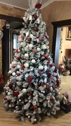 a white christmas tree with red and silver ornaments