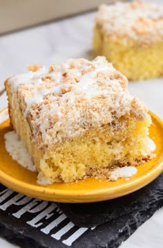 a yellow plate topped with a piece of cake on top of a white and black table