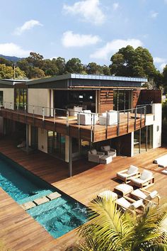 an aerial view of a house with a swimming pool and deck area in the foreground