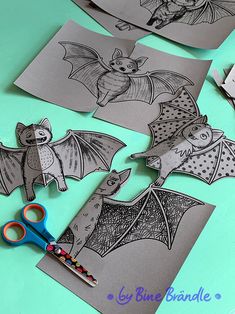 paper cut outs with pictures of bats on them and scissors sitting next to each other