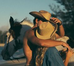 a man riding on the back of a brown and white horse next to a woman