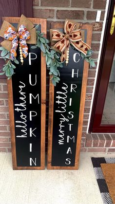 two wooden signs with bows on them sitting in front of a brick wall next to a door