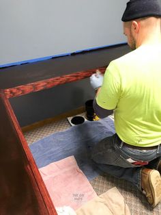 a man in yellow shirt painting a wooden table