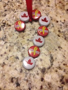 six canadian buttons are arranged in the shape of a heart on a granite countertop