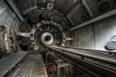 the inside of a large metal structure with lots of pipes and grates on it