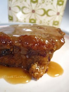 a piece of cake sitting on top of a white plate covered in caramel sauce