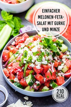 a salad with cucumbers, tomatoes and feta cheese in a bowl on a table