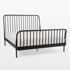 a black metal bed frame with white sheets