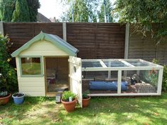 a small white chicken coop in the backyard