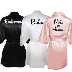 three bridesmaids robes with maid of honor written on the back in black, white and pink