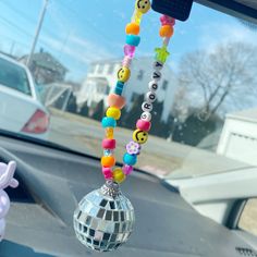 a car dashboard with a mirror ball hanging from it's dash board and beads