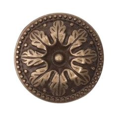 an antique style metal knob with decorative designs on the front and back side, is shown