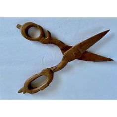 a pair of wooden scissors sitting on top of a white table