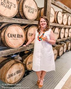 a woman standing in front of some wooden barrels