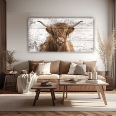 a living room with a couch, coffee table and cow painting on the wall above it