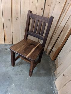 a wooden chair sitting on top of a cement floor