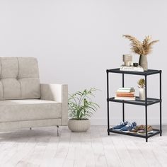 a living room with a couch, chair and plant on the shelf next to it