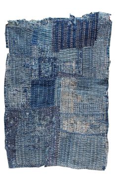 an old patchwork rug with blue and grey colors on it, including squares in the middle