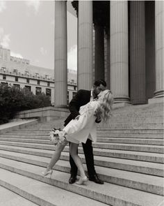 a man and woman kissing on the steps of a building