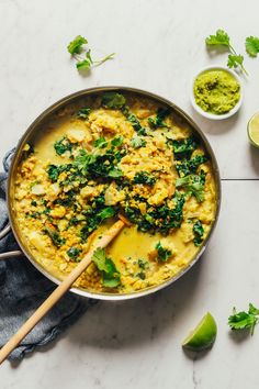 a pan filled with food and garnished with cilantro, parsley and lime