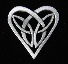 a silver heart shaped brooch with two intertwined hearts in the center on a black background