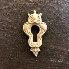 an ornate door handle on a wooden surface