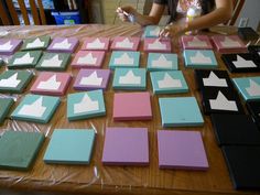 a woman sitting at a table with several pieces of paper on it, including squares and rectangles