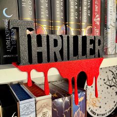 a book shelf filled with books covered in red and black letters that spell out the word thrilr