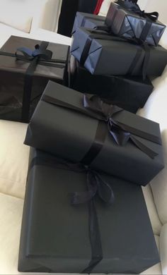 black wrapped presents sitting on top of a white couch