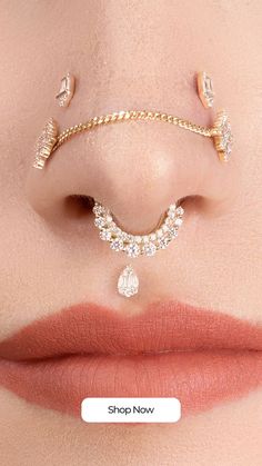 a woman's nose with gold chains and jewels attached to her nose, on top of the lip