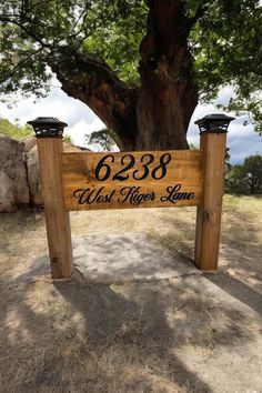 a wooden sign that says,'west river lane'in front of a large tree