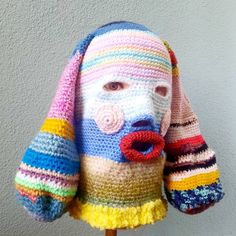 a crocheted dog head with multicolored stripes on it's face