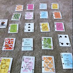 playing cards laid out on the floor with words and phrases written on them, all in different colors