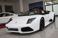 a white sports car parked in a showroom