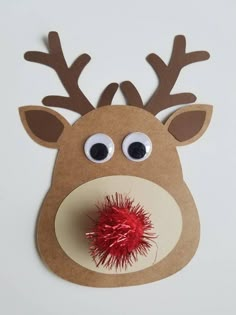 a reindeer head with googly eyes and a red ball in its mouth on a white background