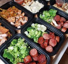 six plastic trays filled with different types of food on top of a wooden table