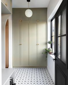 an empty room with white and black flooring next to a large cabinet in the corner