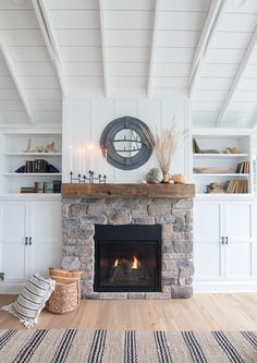 a living room with a fire place and bookshelves on the wall above it