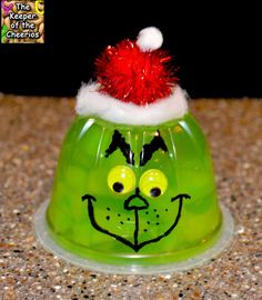 a green glass bell with a red santa hat on top