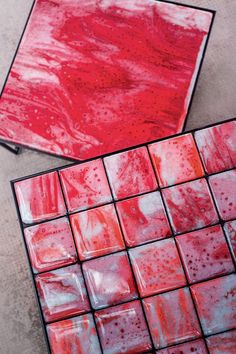 two red tiles sitting on top of a cement floor