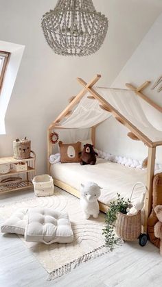 a child's bedroom with a canopy bed and stuffed animals on the floor in front of it